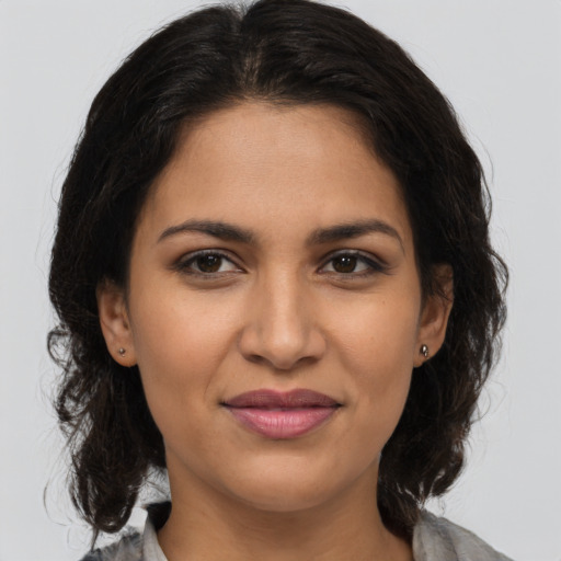 Joyful latino young-adult female with medium  brown hair and brown eyes