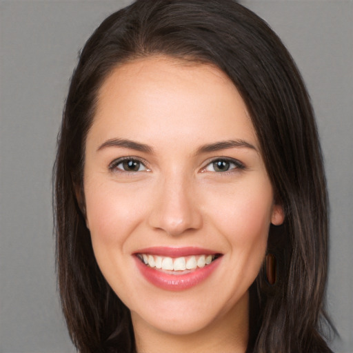 Joyful white young-adult female with long  brown hair and brown eyes