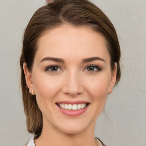 Joyful white young-adult female with medium  brown hair and grey eyes