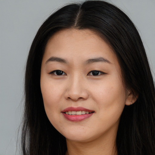 Joyful asian young-adult female with long  brown hair and brown eyes