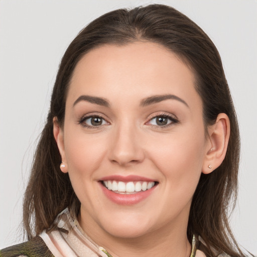 Joyful white young-adult female with medium  brown hair and grey eyes