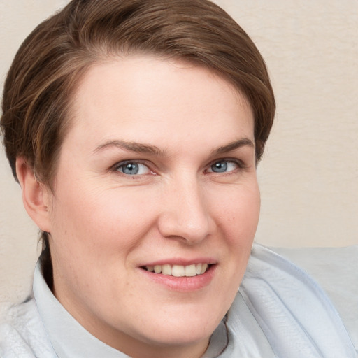 Joyful white young-adult female with short  brown hair and blue eyes