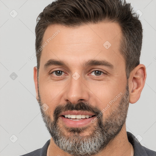 Joyful white adult male with short  brown hair and brown eyes