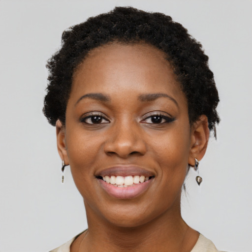 Joyful black young-adult female with short  black hair and brown eyes