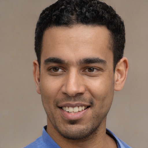Joyful latino young-adult male with short  black hair and brown eyes