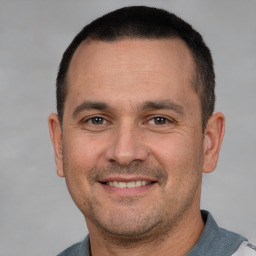 Joyful white adult male with short  brown hair and brown eyes