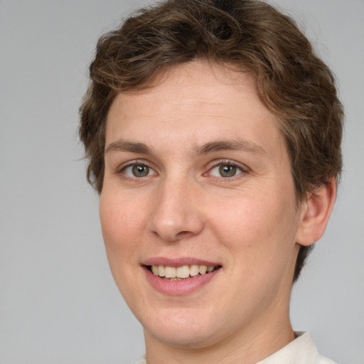 Joyful white young-adult female with short  brown hair and green eyes