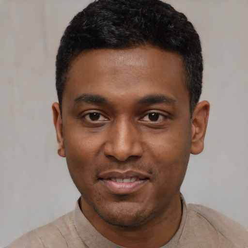 Joyful black young-adult male with short  black hair and brown eyes