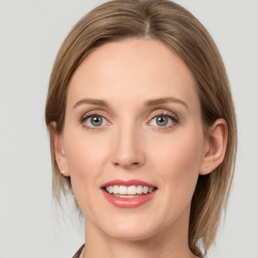 Joyful white young-adult female with medium  brown hair and green eyes