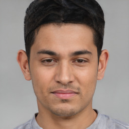 Joyful white young-adult male with short  black hair and brown eyes