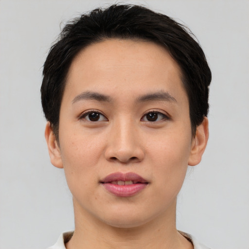 Joyful asian young-adult female with short  black hair and brown eyes