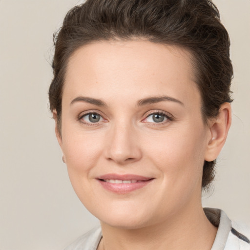 Joyful white young-adult female with short  brown hair and grey eyes