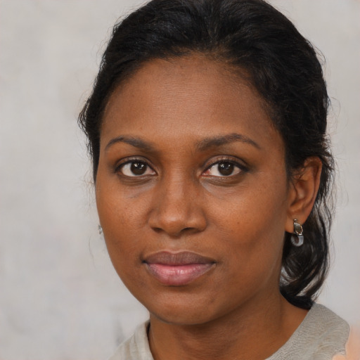 Joyful black adult female with medium  brown hair and brown eyes