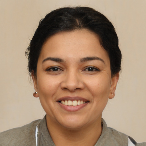 Joyful latino young-adult female with medium  brown hair and brown eyes