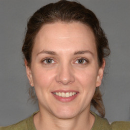 Joyful white young-adult female with medium  brown hair and blue eyes