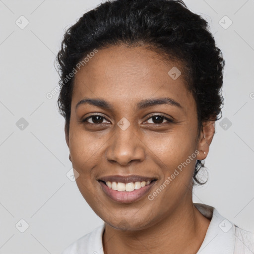 Joyful black young-adult female with short  black hair and brown eyes