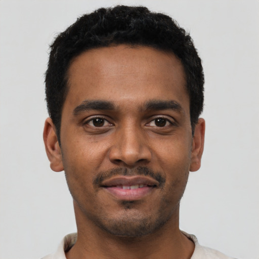 Joyful black young-adult male with short  black hair and brown eyes