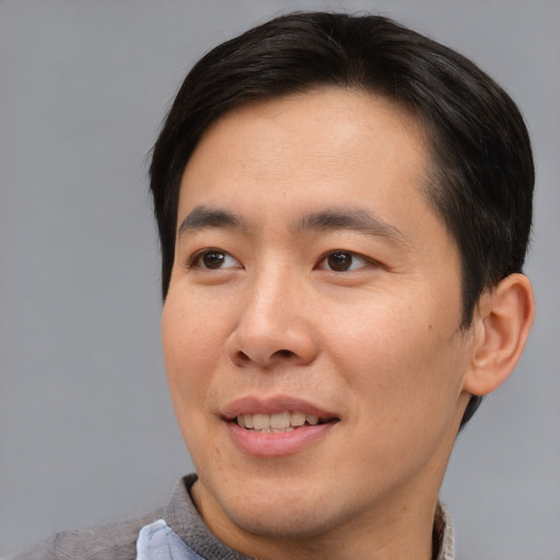 Joyful asian young-adult male with short  brown hair and brown eyes