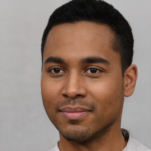Joyful black young-adult male with short  black hair and brown eyes
