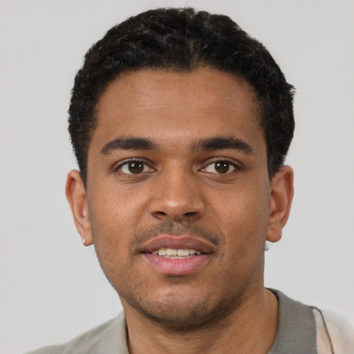Joyful black young-adult male with short  brown hair and brown eyes