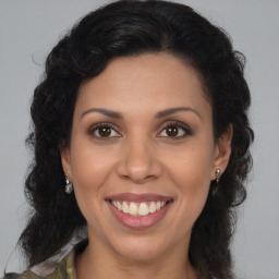 Joyful latino young-adult female with long  brown hair and brown eyes