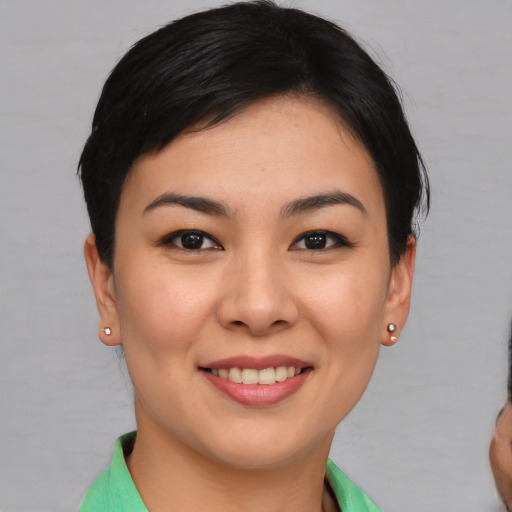Joyful asian young-adult female with short  brown hair and brown eyes