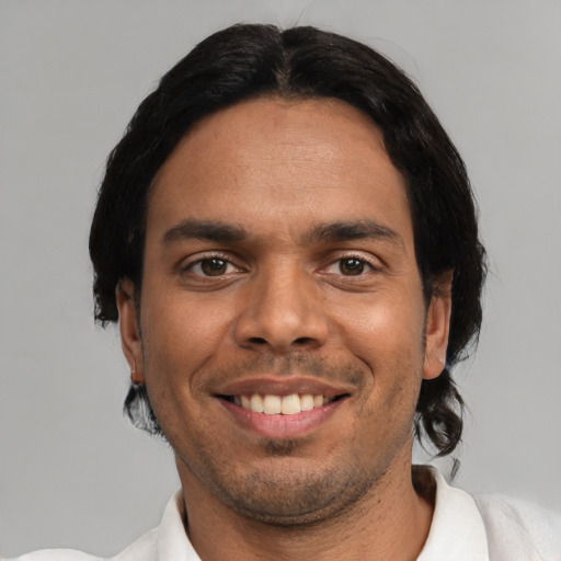 Joyful latino young-adult male with short  black hair and brown eyes