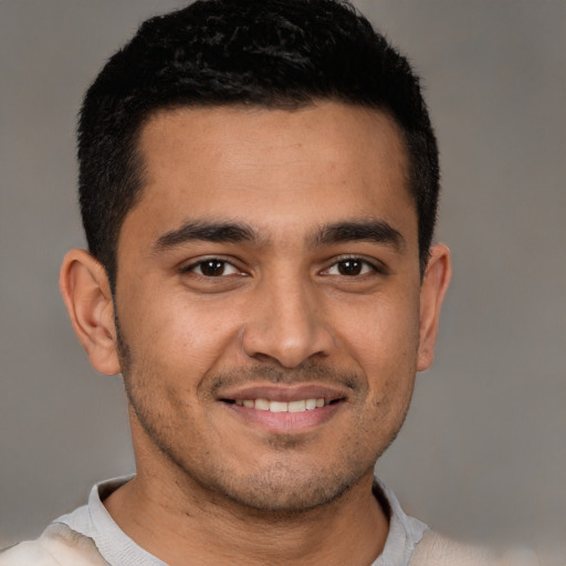 Joyful latino young-adult male with short  brown hair and brown eyes