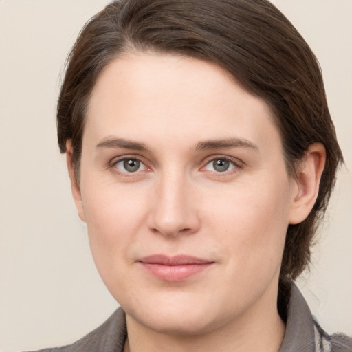 Joyful white young-adult female with medium  brown hair and grey eyes