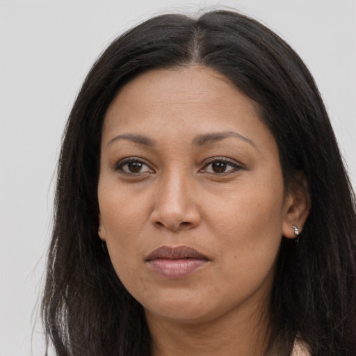 Joyful latino adult female with long  brown hair and brown eyes