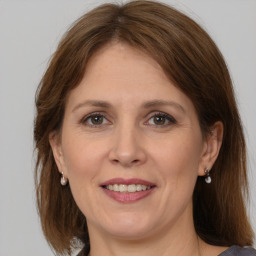 Joyful white adult female with medium  brown hair and grey eyes