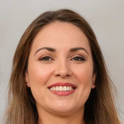 Joyful white young-adult female with long  brown hair and brown eyes