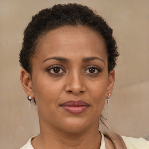 Joyful black young-adult female with short  brown hair and brown eyes