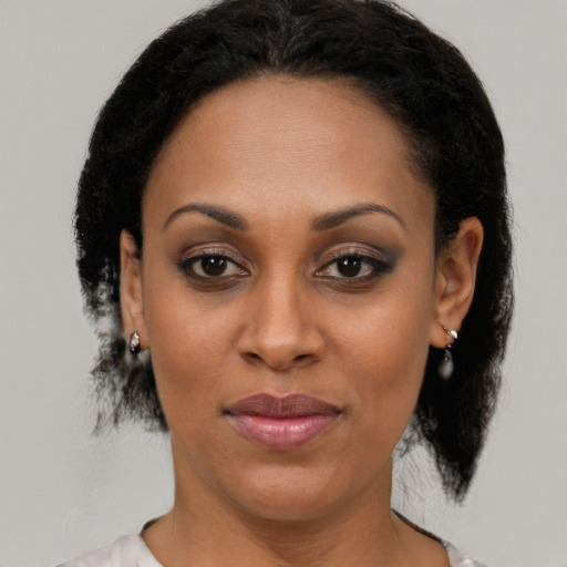 Joyful black adult female with medium  brown hair and brown eyes