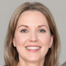 Joyful white adult female with medium  brown hair and grey eyes