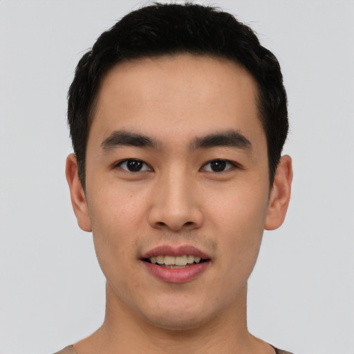 Joyful asian young-adult male with short  black hair and brown eyes