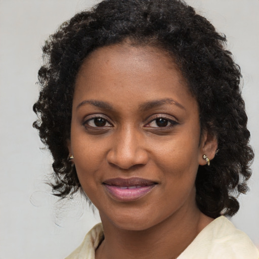 Joyful black young-adult female with long  brown hair and brown eyes