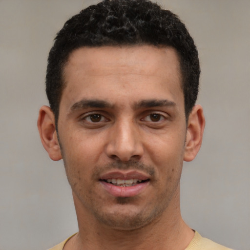 Joyful white young-adult male with short  black hair and brown eyes