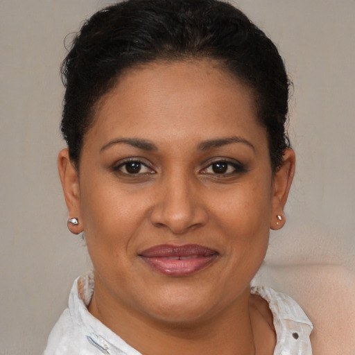 Joyful latino adult female with short  brown hair and brown eyes