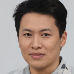 Joyful asian young-adult male with short  black hair and brown eyes