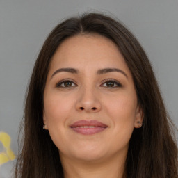 Joyful white young-adult female with long  brown hair and brown eyes