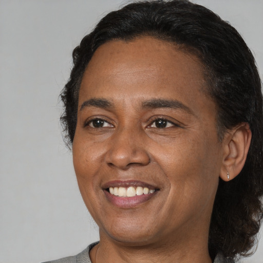 Joyful black adult female with medium  brown hair and brown eyes