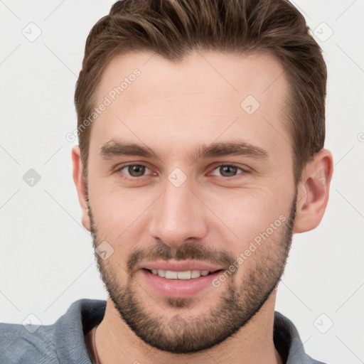 Joyful white young-adult male with short  brown hair and grey eyes