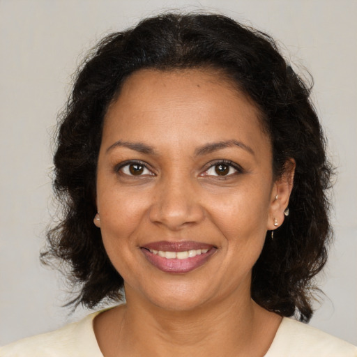 Joyful black adult female with medium  brown hair and brown eyes