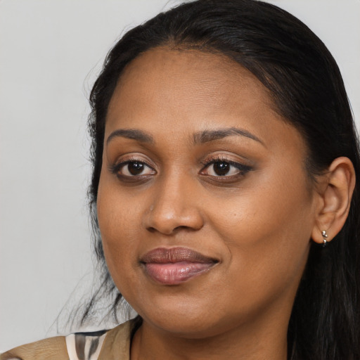 Joyful black young-adult female with long  brown hair and brown eyes