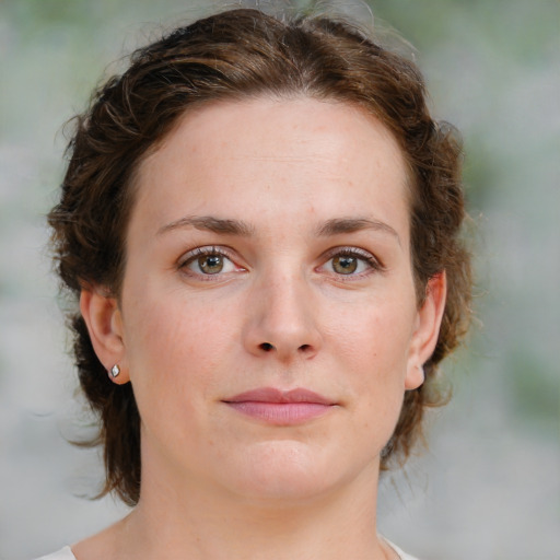 Joyful white young-adult female with medium  brown hair and green eyes