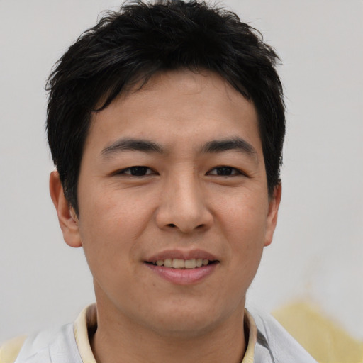 Joyful asian young-adult male with short  brown hair and brown eyes