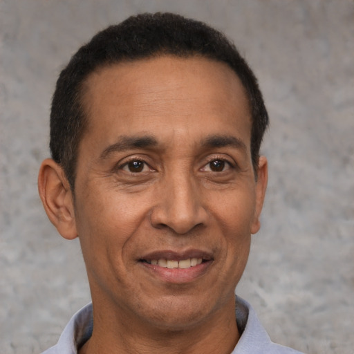Joyful latino adult male with short  black hair and brown eyes