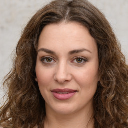 Joyful white young-adult female with long  brown hair and green eyes