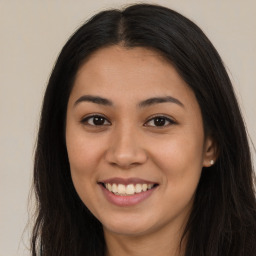 Joyful latino young-adult female with long  brown hair and brown eyes